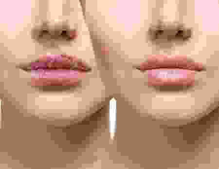 A woman 's face with pink lipstick on her lips.