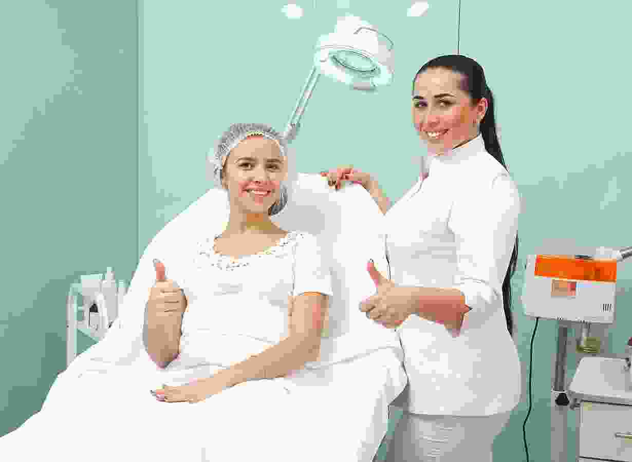 A woman is getting her hair cut by an esthetician.