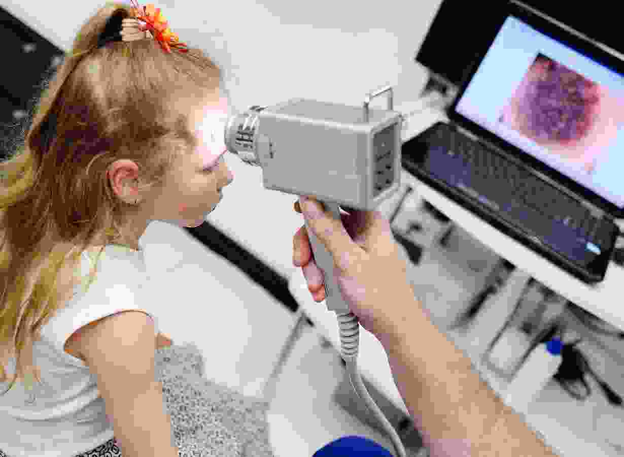 A child is being examined by an optometrist.