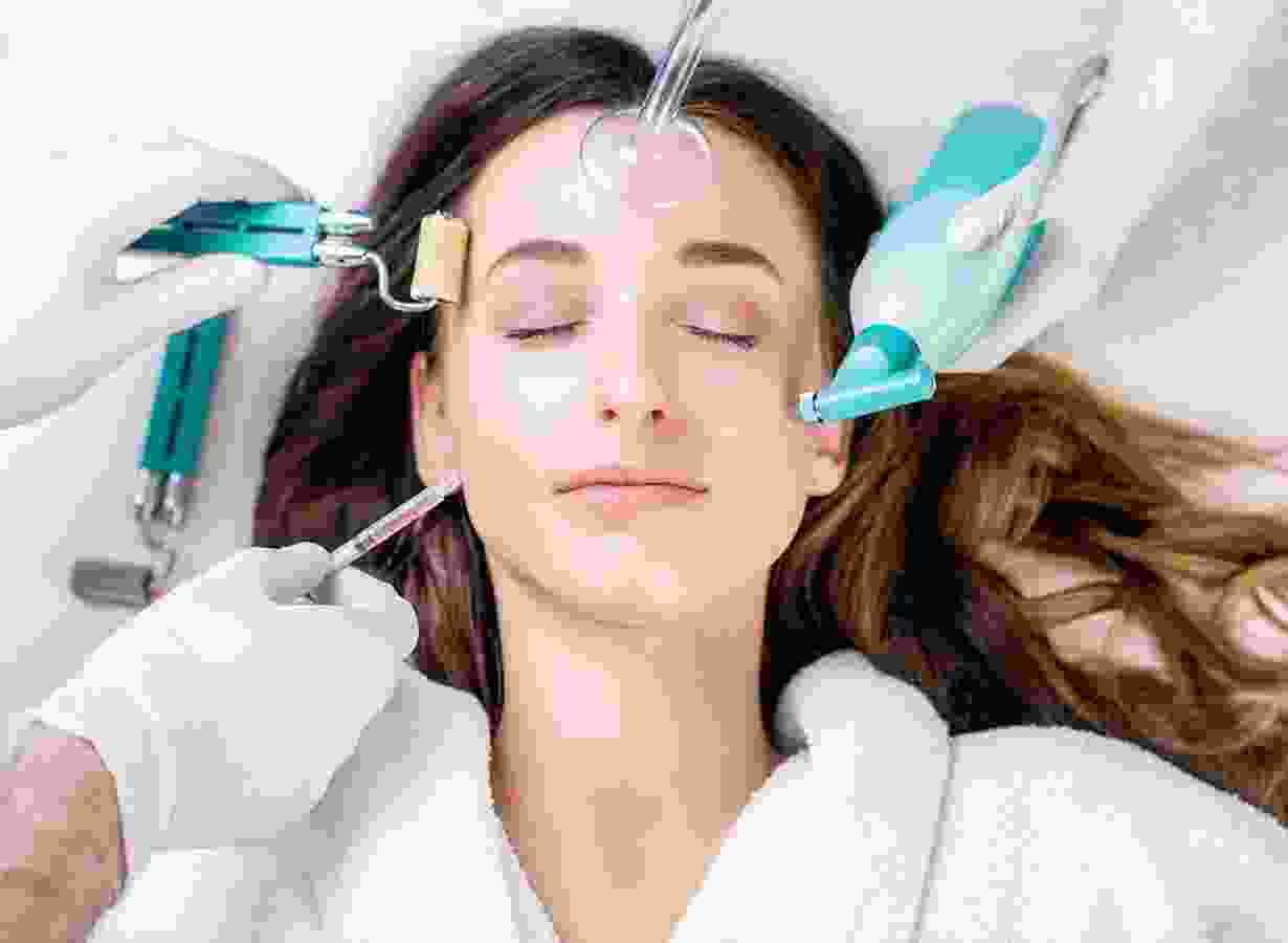 A woman is getting her face waxed by two hands.