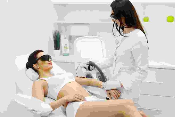 A woman getting her teeth checked by an esthetician.