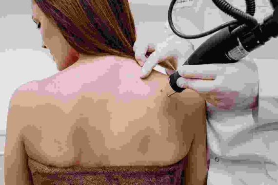 A woman getting her back shaved off by a doctor.