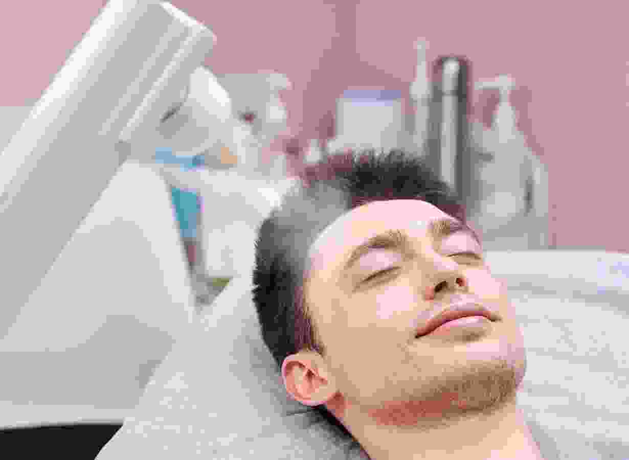 A man is getting his hair cut at the salon.