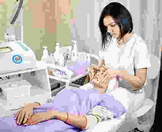 A woman is giving an elderly man a manicure.