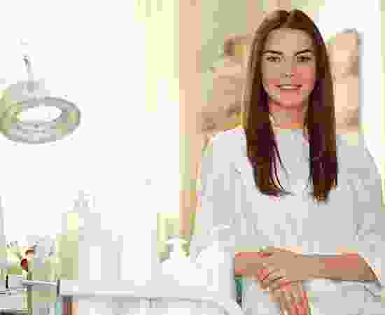 blog-detail-14 A woman in white shirt standing next to a table.
